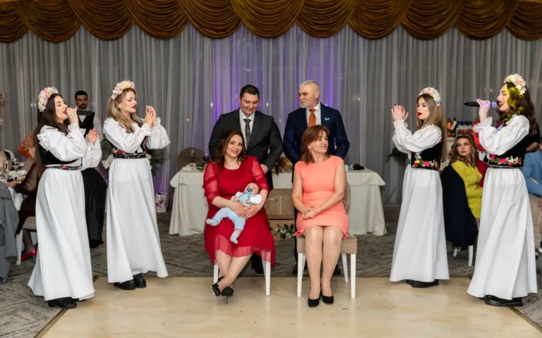 Dansatori în costume populare cântă în jurul familiei cu copilul