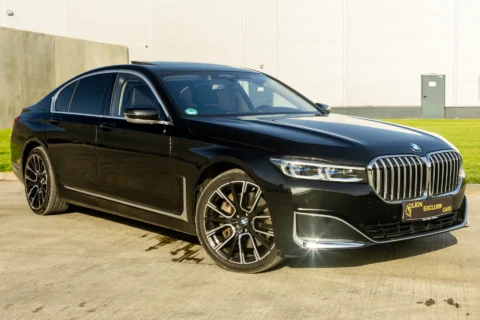 BMW Seria 7 negru fotografiat din față, în lumina apusului, pentru un dealer auto