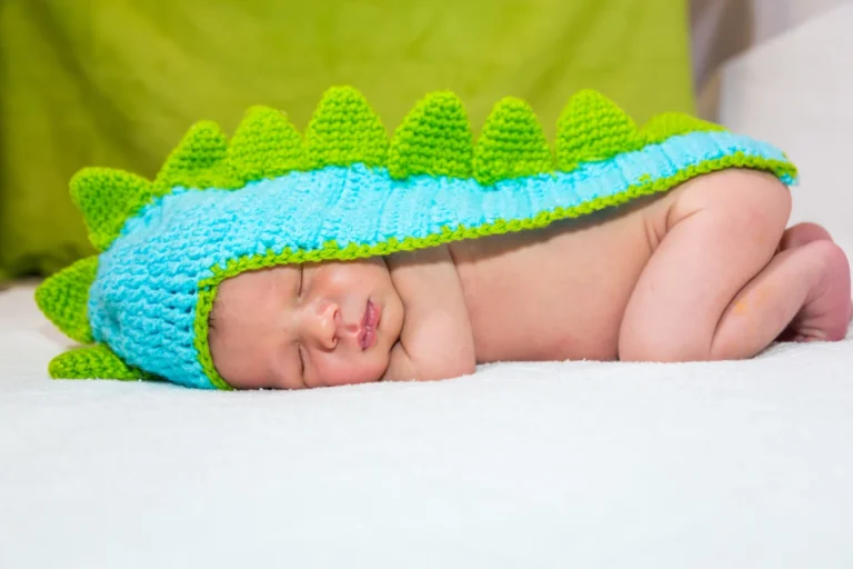 Bebeluș dormind în costum de dinozaur croșetat, albastru cu verde