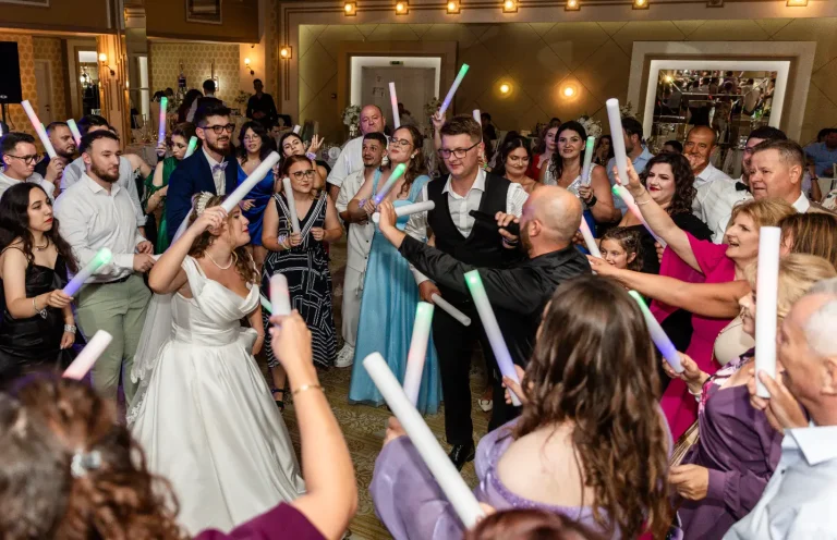 Mireasa printre invitați cu bețe luminoase, pe ringul de dans
