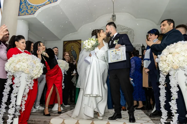 Sărutul mirilor la ieșirea din biserică, cu nașii alături