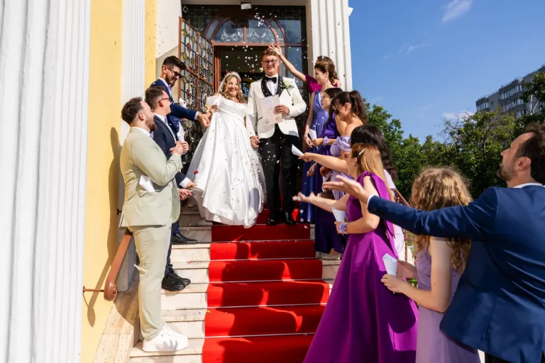 Ieșirea mirilor din biserică, întâmpinați de invitați cu petale