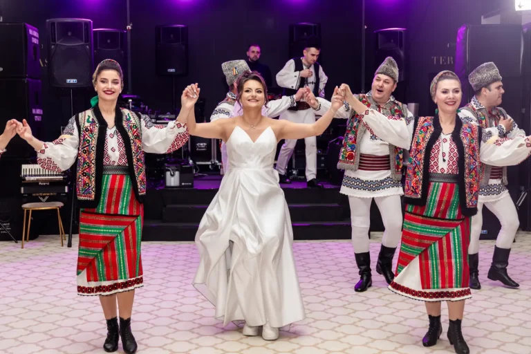 Mireasa dansând hora cu dansatori în costume populare