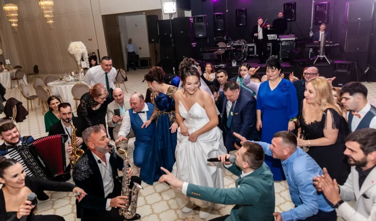 Invitații dansând în jurul mirilor, cu saxofonist