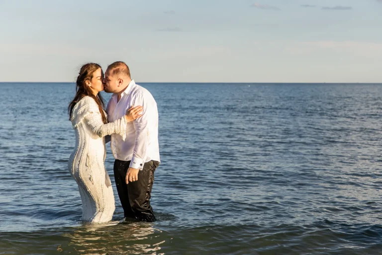Sărutul mirilor în mare, cu apa până la genunchi